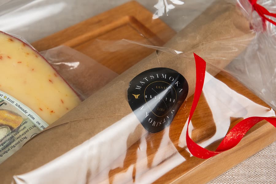 Käsitöö kinkepakk tsellofaanis – salaami ja juust puidualusel