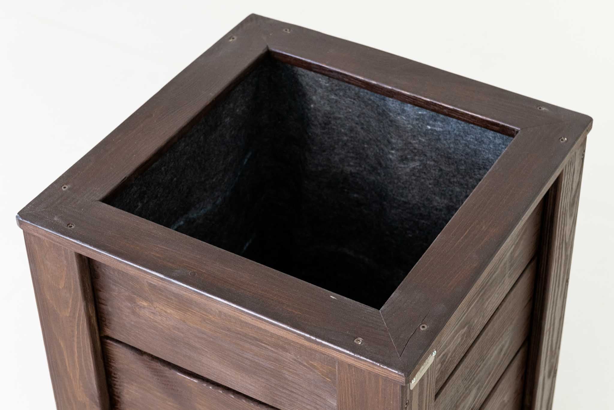 Pruun puidust taimekast terrassil kasutuses